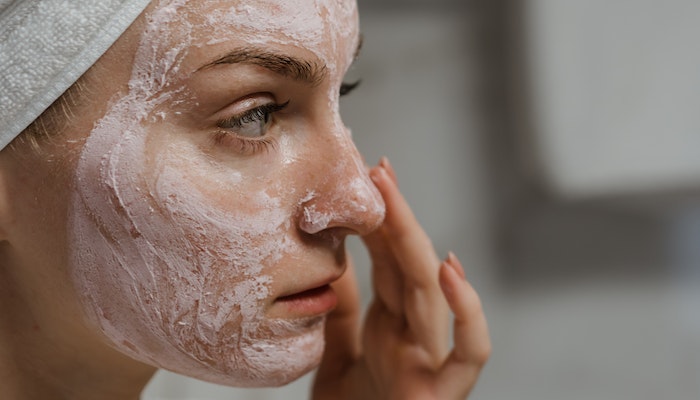 A Girl applying moisturizer on face to make skin healthy and glowing