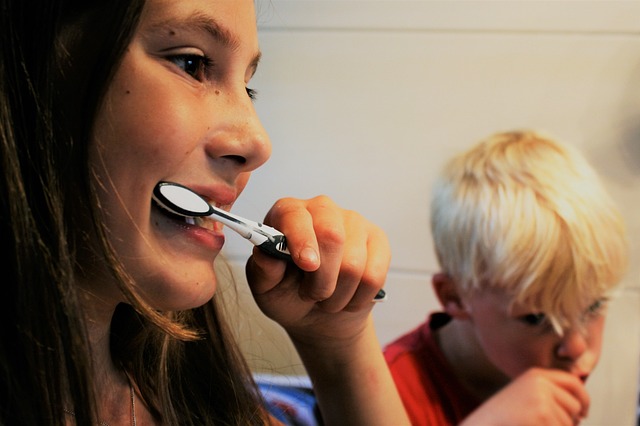 Woman brushing teeth with his kid